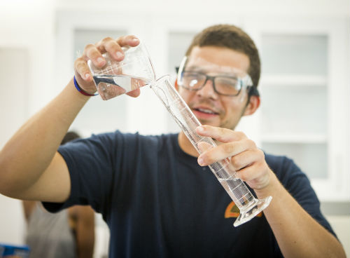 Student pouring liquid into a beaker
